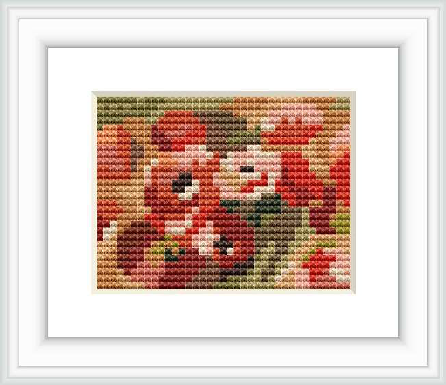 A cross stitch representation of Pierre-Auguste Renoir's artwork featuring anemones. The stitched piece captures the essence of the floral theme with a palette of reds, greens, and neutral tones.