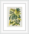 The image showcases a framed cross stitch pattern of various ivy leaves depicted in segments of green and yellow shades. The pattern is set against a white background within a simple frame, highlighting its design.
