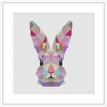 The image depicts a cross stitch pattern of a geometrically styled bunny head with a colorful patchwork design. It is centered on a white canvas.