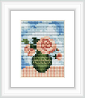 The image displays a framed cross stitch design containing a vase with spring flowers against a sky blue background.