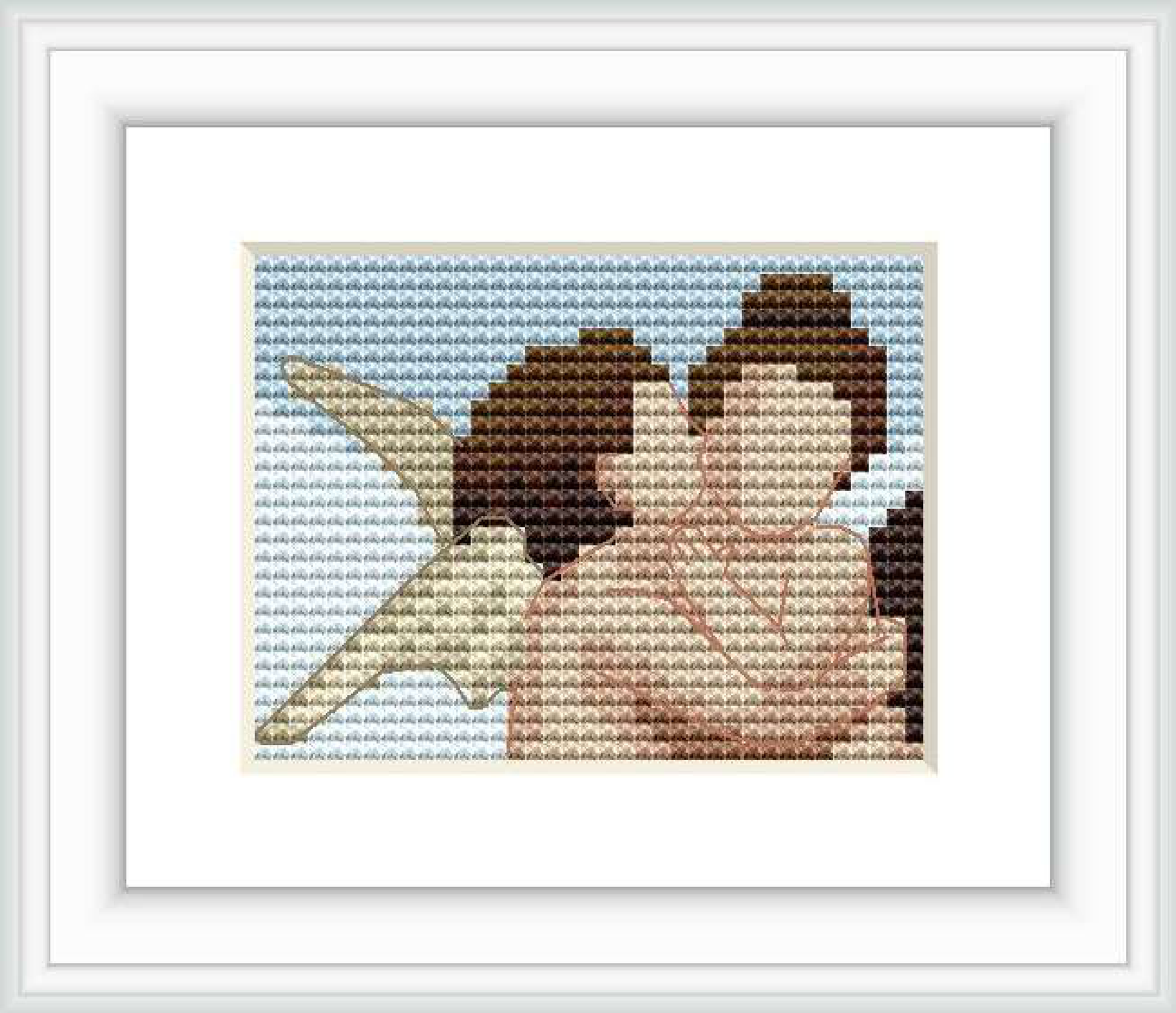 The cross stitch pattern depicts two cherubic figures closely embracing against a backdrop of soft blue sky with wisps of white clouds.