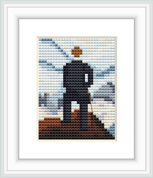 The cross stitch pattern shows a pixelated figure of a man standing on a promontory over a sea of fog, with his back facing the viewer. The landscape is composed of shades of blue, gray and touches of brown and white, representing a misty atmosphere.