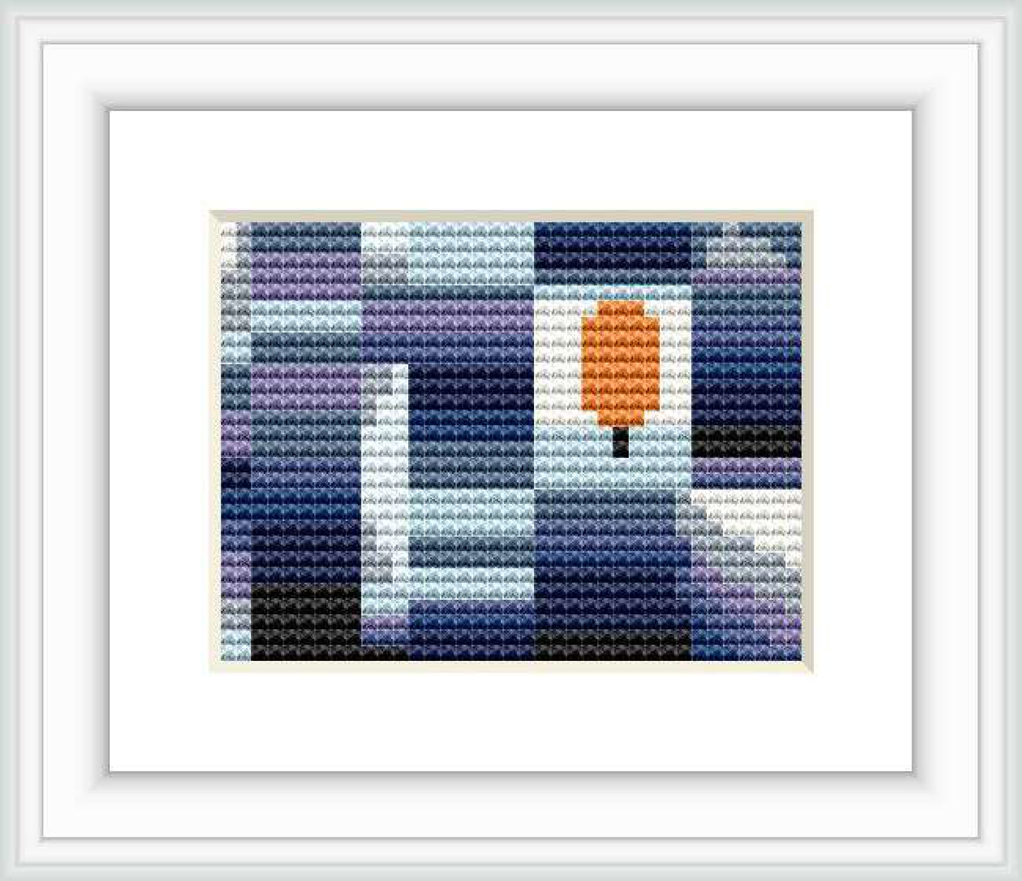 The image shows a framed cross stitch pattern consisting of blocks of color forming a pixelated design, with a dominant central orange block resembling a leaf surrounded by a background of various shades of blue, purple, white, and gray.