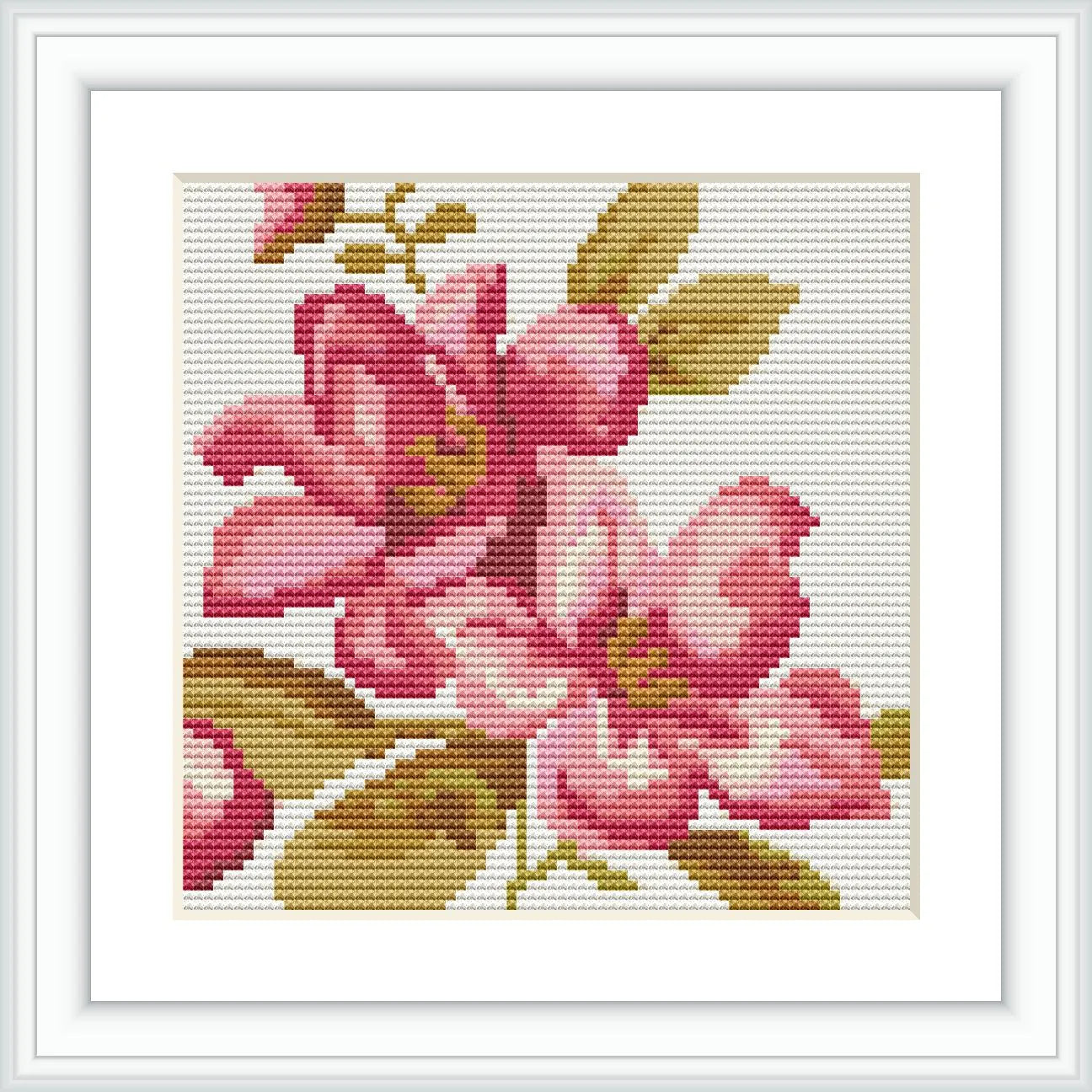 This is a framed cross stitch pattern of four soft pink flowers with green leaves on a white background.