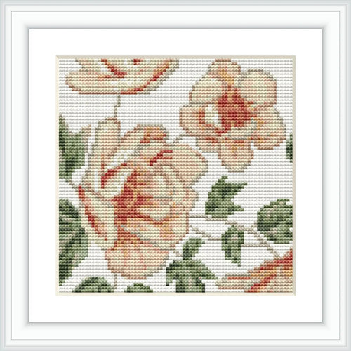The image showcases a framed cross-stitch embroidery featuring three beige flowers with green leaves of varying shades. The embroidery is patterned on a white even-weave fabric.