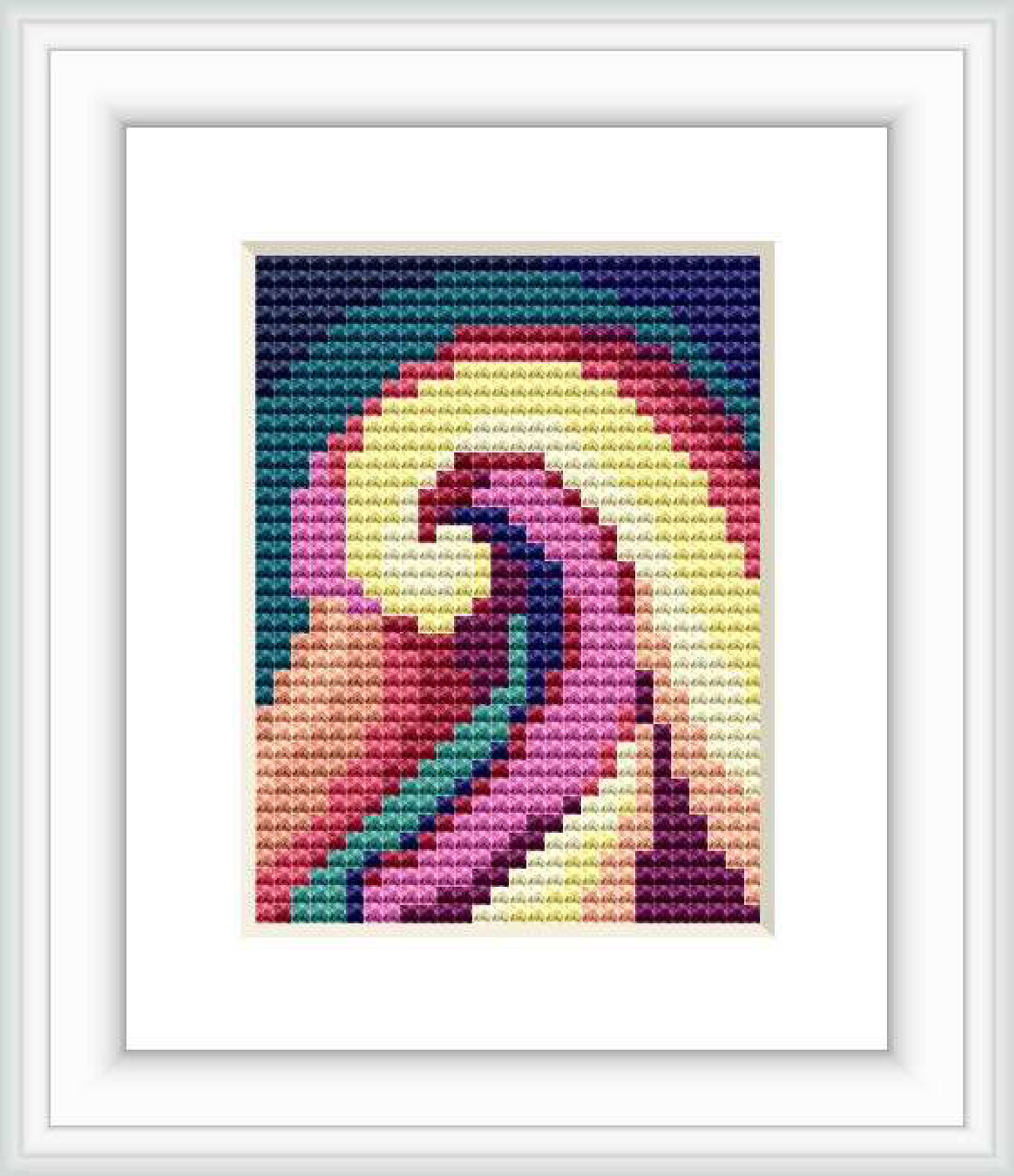 The image showcases a framed cross stitch pattern with abstract floral design reminiscent of Georgia O'Keeffe's style. The design features a range of colors and is displayed within a simple white frame against a white background.