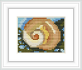 The image displays a detailed cross stitch pattern framed in white. It depicts a stylized marine shell surrounded by suggestions of seaweed, primarily in shades of pink and beige, against a blue and white background.