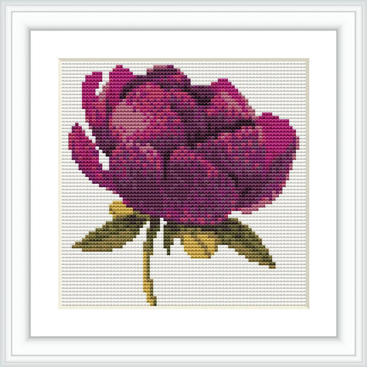 The image shows a cross stitch design of a dark purple flower with green and gold stems and leaves, neatly framed, against a white background.