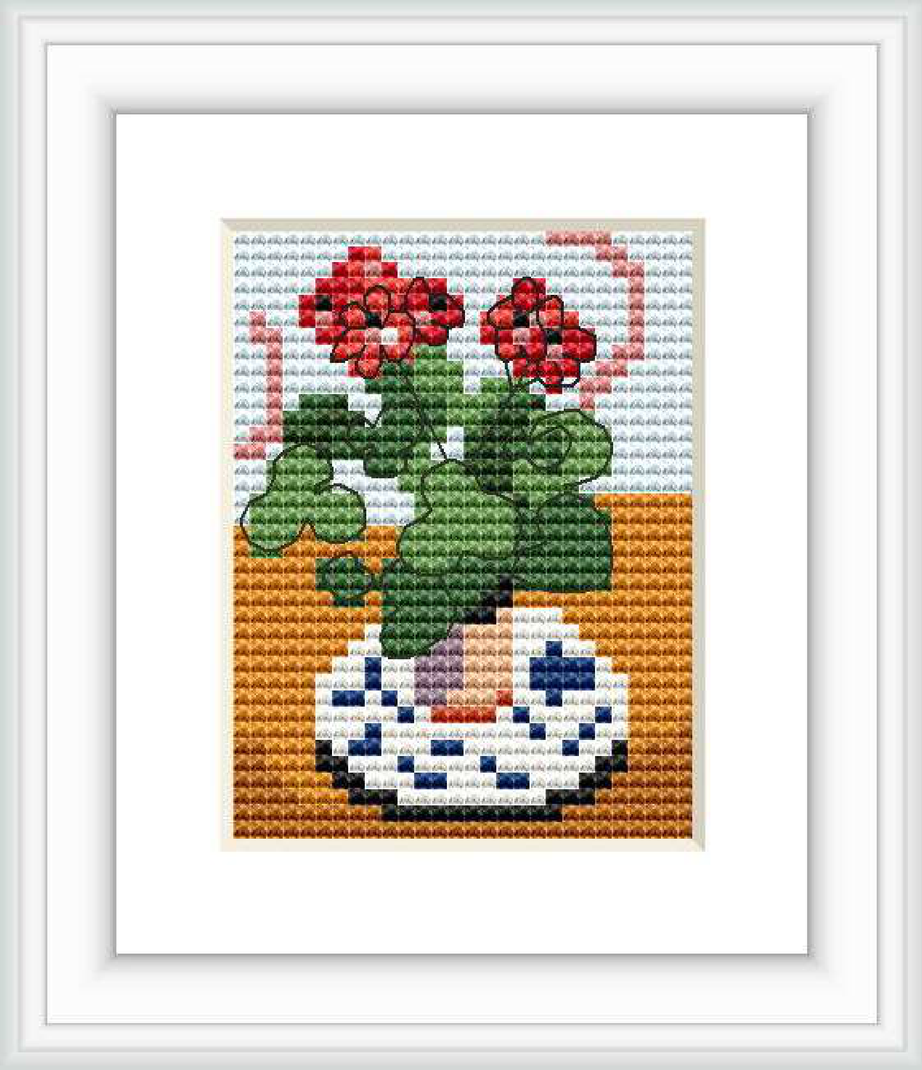 The image depicts a cross stitch pattern of red geraniums in a vase with blue and white patterns, set against an orange and white backdrops.