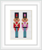 The image displays two toy soldiers standing side by side. They are designed in a pixelated cross stitch pattern with uniformed attire, one in red and the other in pink, against a white background framed with a simple white frame.