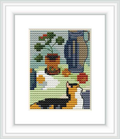 The cross stitch pattern features a black cat sitting beside a flower pot with red blossoms, a large blue vase, and a smaller patterned vase on alternating colored tiles.
