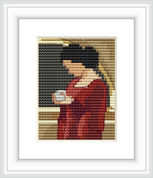 The cross stitch design depicts a side profile of a woman in a red dress, holding a crystal ball in her hands, against a dark background with a golden edge.