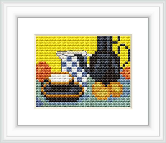 The cross stitch pattern depicts a still life scene with a blue enamel coffeepot, accompanied by other kitchen items such as a teapot and cups, arranged against a backdrop with a blend of vivid colors creating a checkerboard effect.