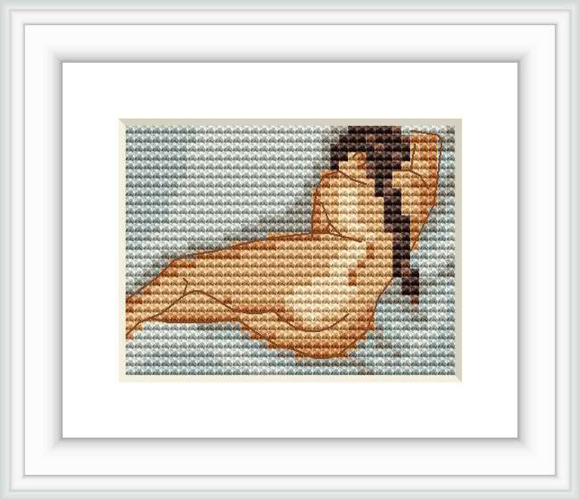 The image shows a framed miniature cross stitch pattern depicting a figure reclining from the back view. The figure is resting against a light blue background and is framed with a white border.