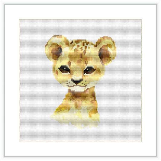 This is a cross stitch pattern of a baby lion cub's face, centered on a white background. The cub is depicted in a simplified, pixelated style with a limited color palette.