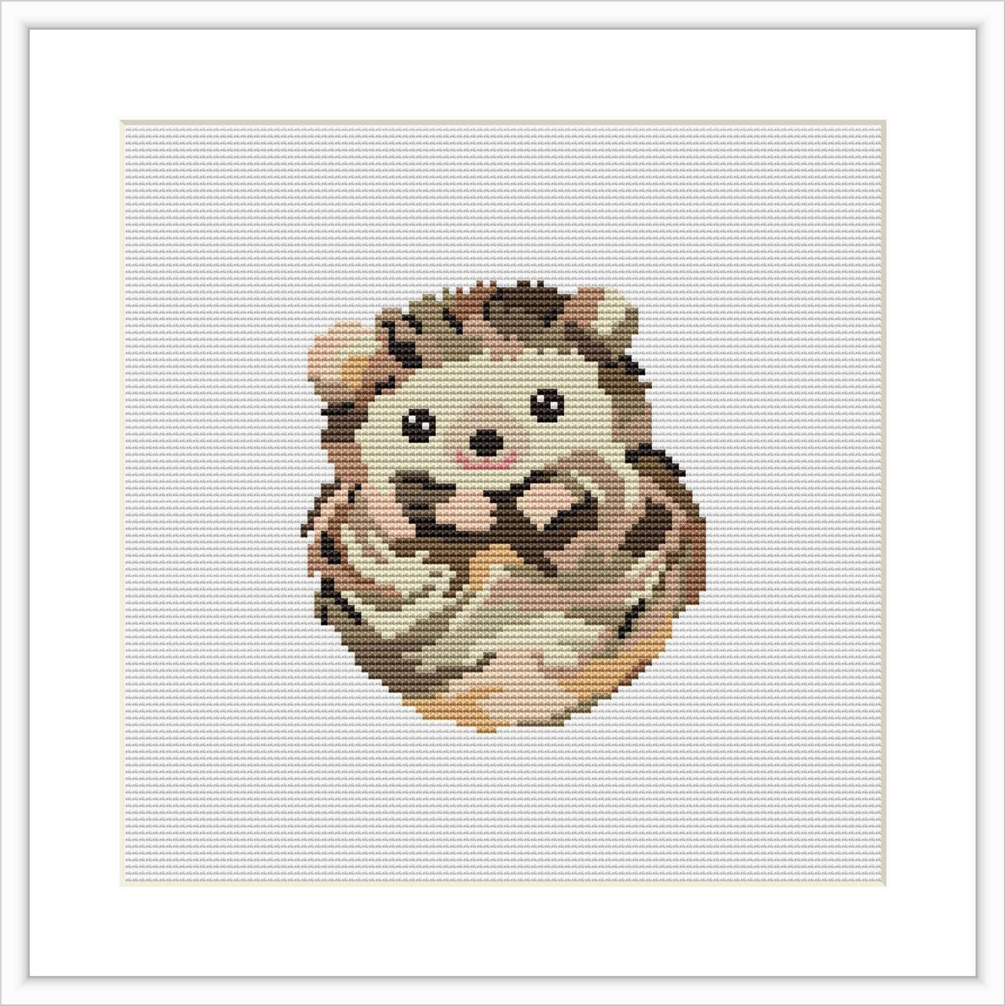 The image displays a cross stitch pattern of a baby porcupine. It is centered in the frame, surrounded by a white border on a white fabric background.