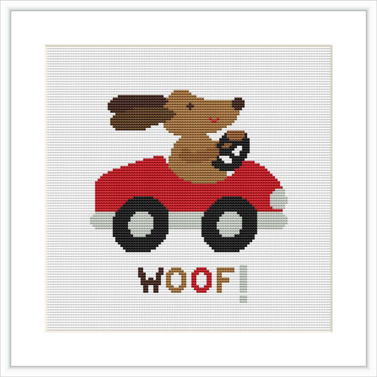 The image depicts a cross stitch pattern featuring a cartoon dog driving a red car with the word 'WOOF!' underneath. The background is white and the pattern is encased in a square frame.