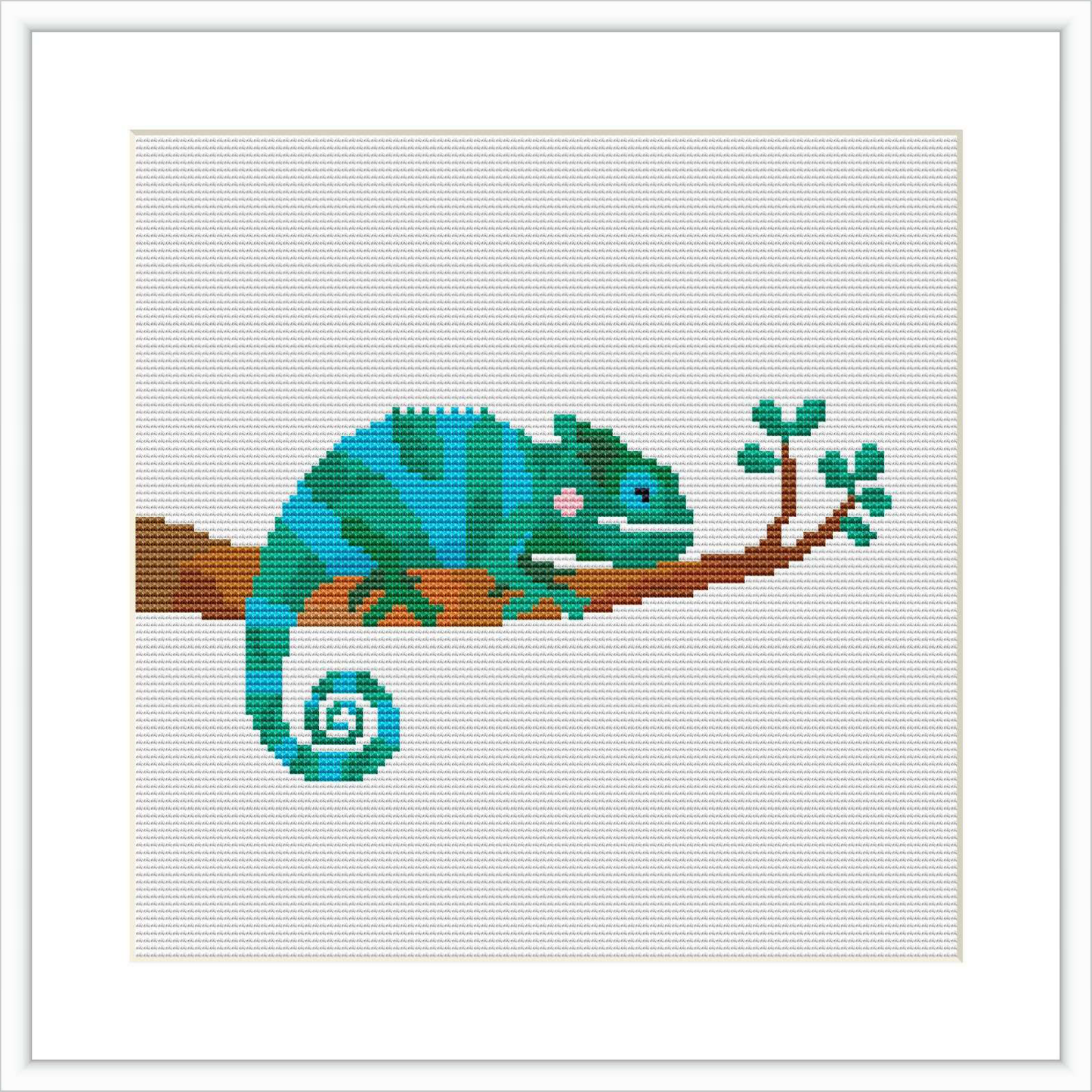 The image features a cross stitch pattern of a turquoise and green chameleon with pink cheeks sitting on a brown branch with green leaves, against a white background.