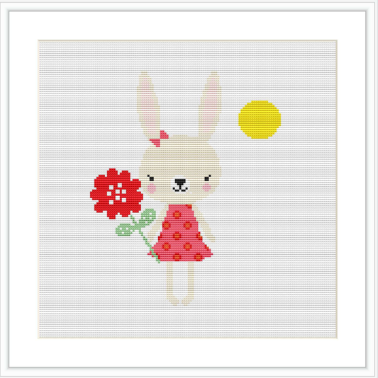 The image displays a cute cartoon bunny in a pink dress with a floral pattern, holding a red flower. A yellow sun is placed in the upper right corner against a plain white background.