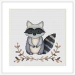 The image shows a framed cross stitch pattern featuring a raccoon with leaves around it. The raccoon is centered on the fabric, surrounded by a simple border and a white background space.