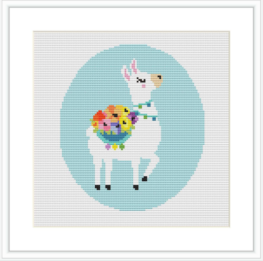 The image is a digital mock-up of a cross stitch pattern showing a stylized white llama with closed eyes, rosy cheeks, and a bouquet of multicolored flowers around its neck. The llama is centered against a blue circular background surrounded by a grid of white cross stitches.