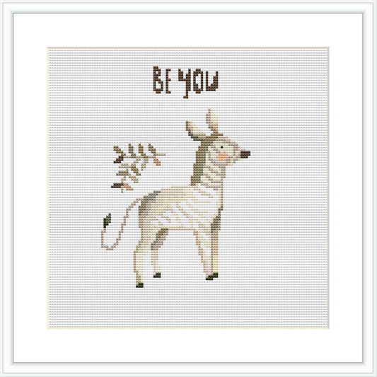 The image shows a cross stitch pattern of a stylized zebra with multiple horns and a leafy tail. The background is plain with the text 'Be you' stitched above the animal.