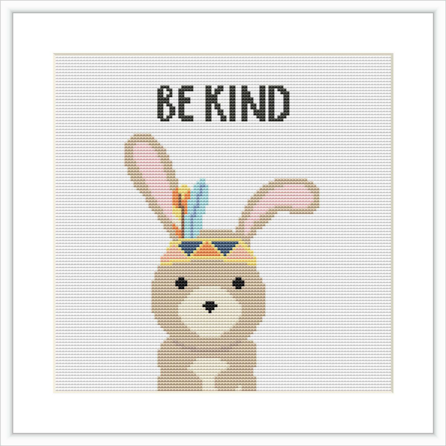 The image showcases a cross stitch pattern featuring a cute brown bunny wearing a crown with colorful feathers. Above the bunny, the phrase 'BE KIND' is stitched in a simple font. The overall design is set against a plain white background, creating a stark contrast that highlights the bunny.