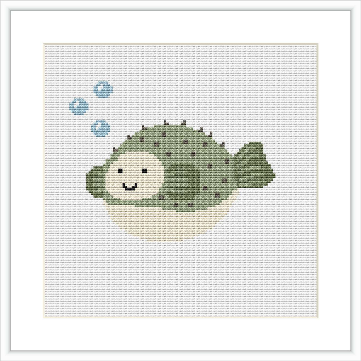 The image displays a cross stitch pattern of a cute, smiling blowfish with green and beige coloring, surrounded by three small blue bubbles, on a white canvas.