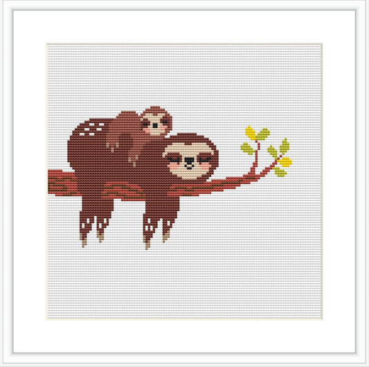 The image depicts a cross stitch pattern of two sloths, one larger and one smaller, hanging from a red branch with a few green leaves sprouting.