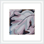 A framed cross stitch pattern that resembles the abstract shapes of leaves with a predominant use of purple hues and a modernist style, placed against a white background.