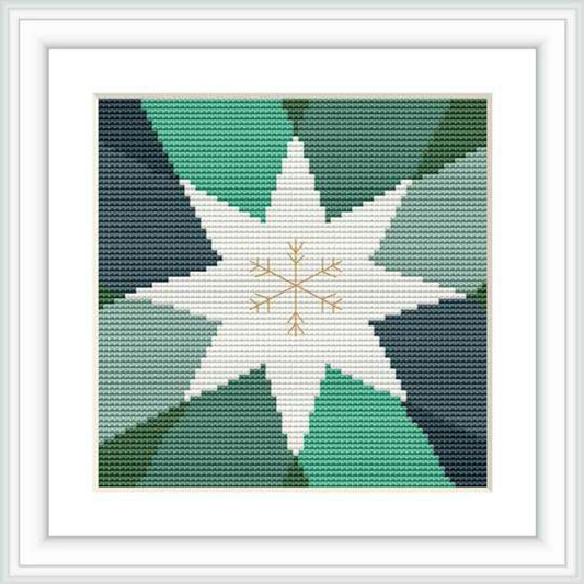 The image displays a cross stitch pattern of a central star with a secondary, smaller starburst in the middle, set against a gradient of teal to dark green background contained within a bordered frame.