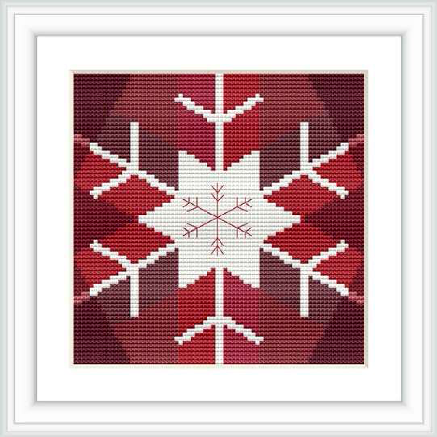 The image shows a cross stitch pattern featuring a central white snowflake on a red background, bordered by a thin white frame.