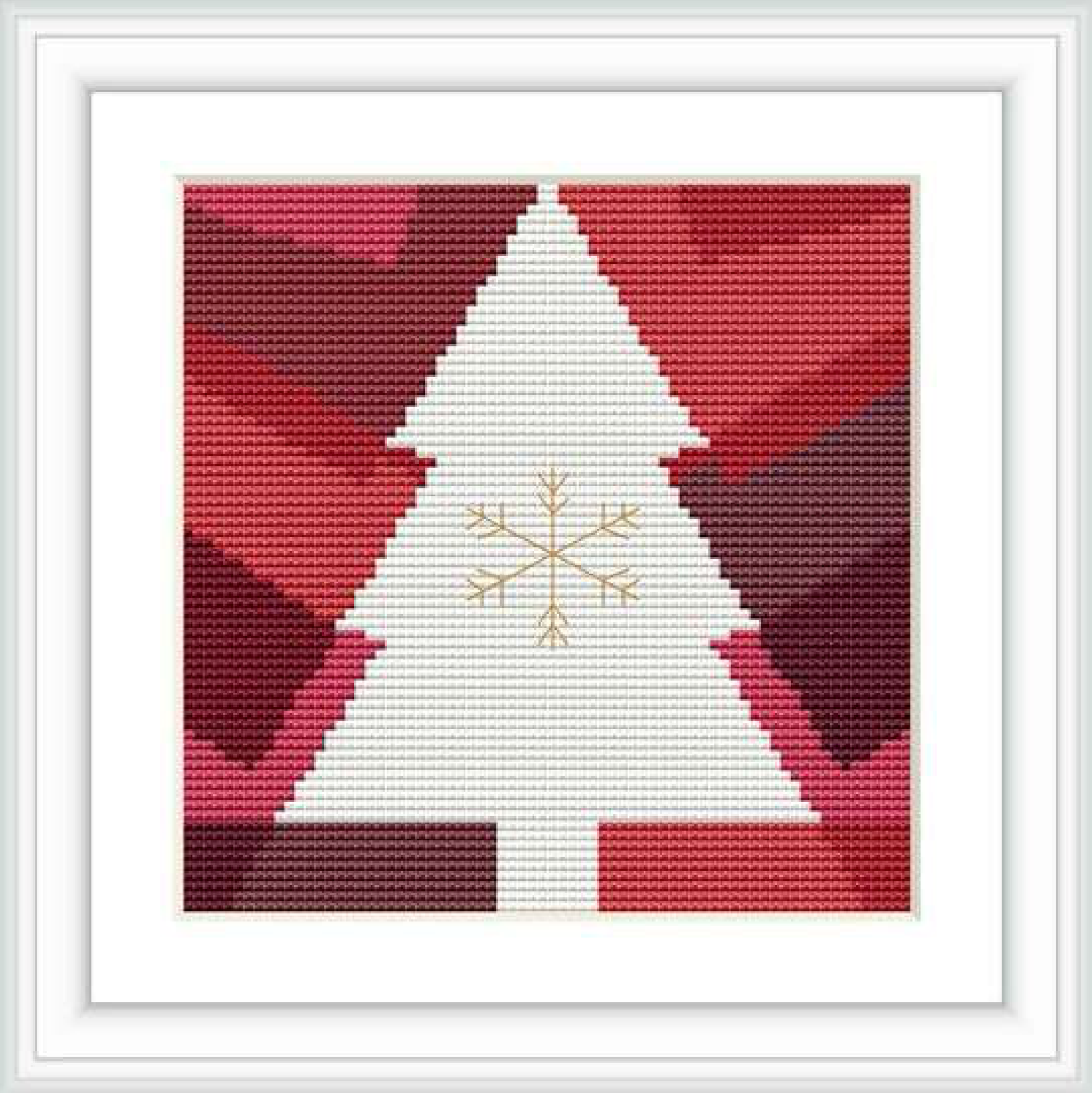 The image shows a framed cross stitch pattern with a white geometric Christmas tree in the center, against a red gradient background. The tree is decorated with a central golden snowflake. The pattern is square in shape with even and symmetrical stitching.