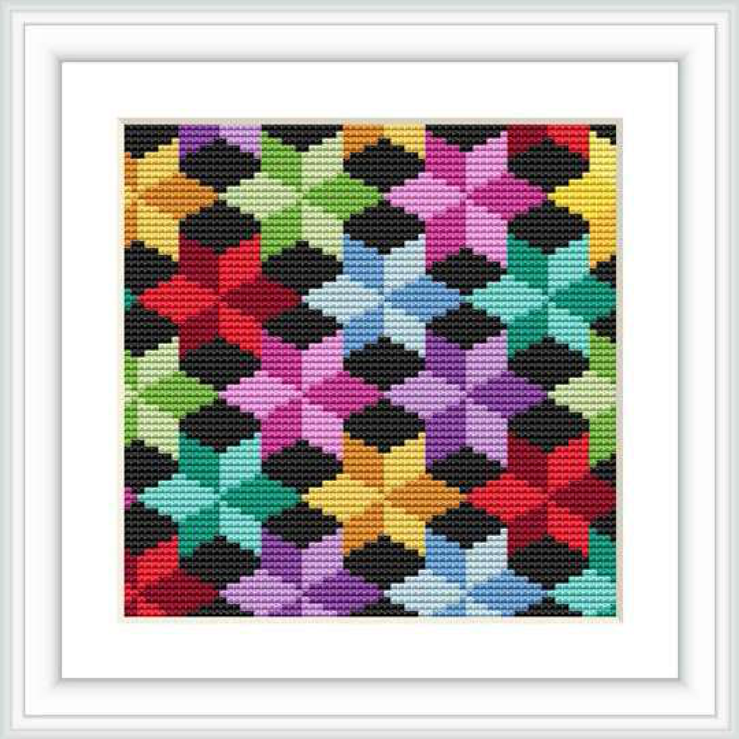 A framed cross stitch piece is displayed, showcasing an array of multicolored geometric shapes resembling stars or flowers arrayed in a regular pattern against a stark black background.