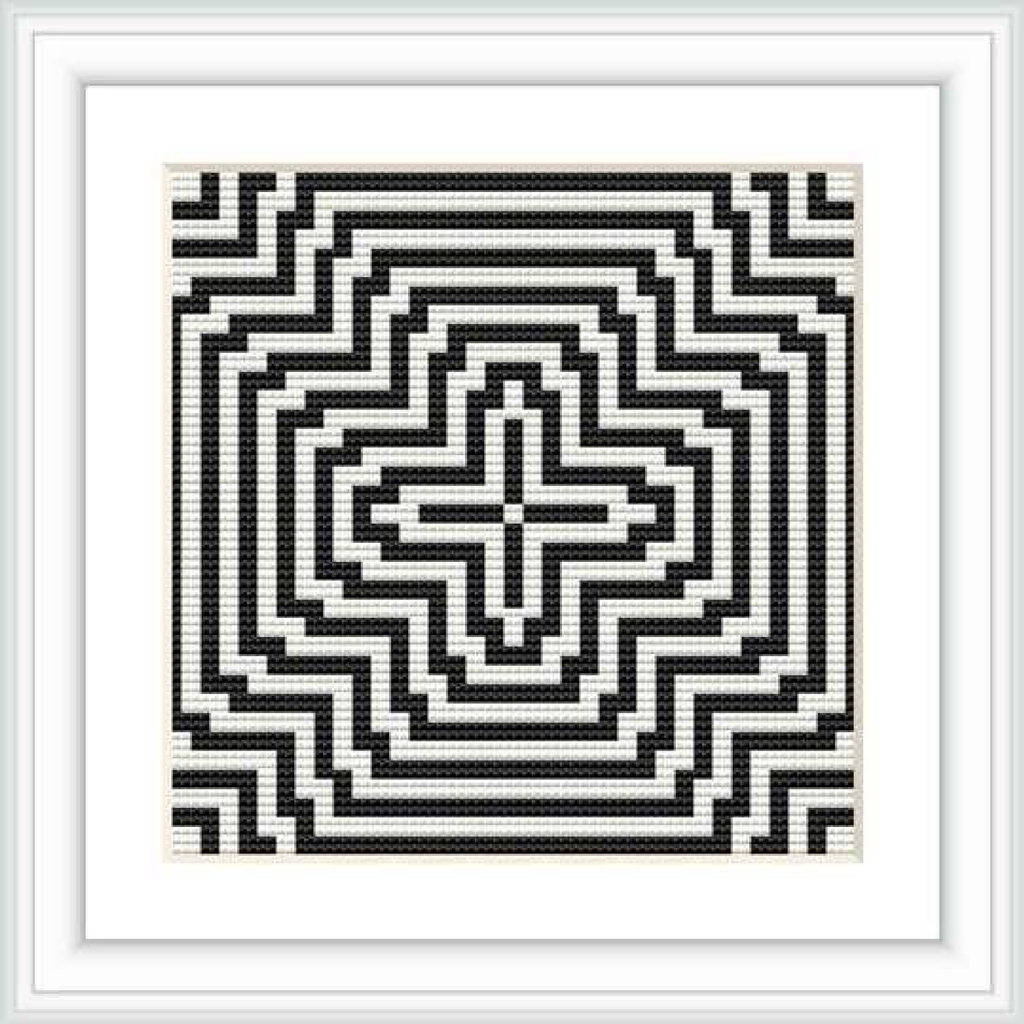 The image shows a cross stitch pattern of geometric design in a square frame, using a monochrome color scheme of black and white.