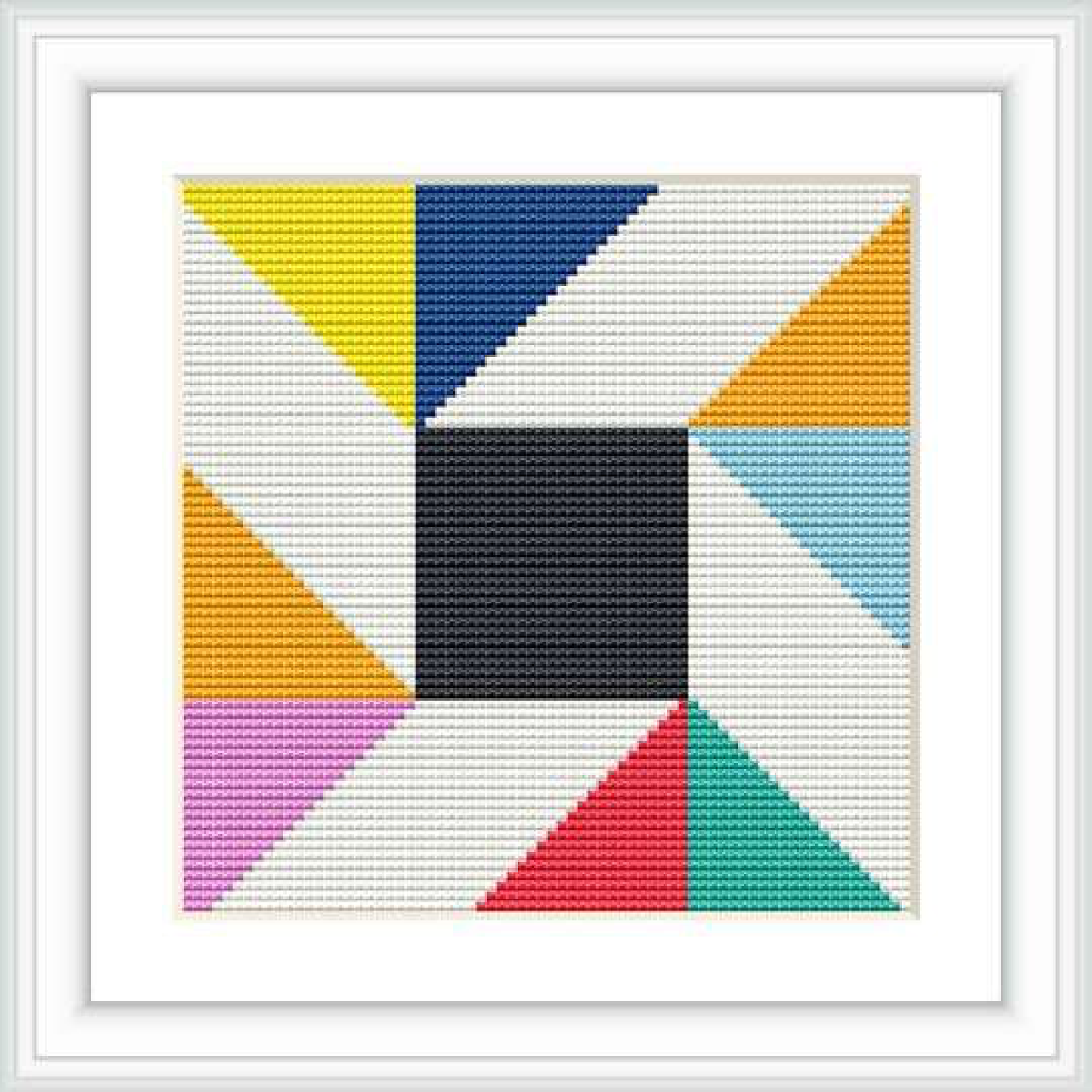 The image shows a framed cross stitch pattern featuring a central black square surrounded by triangles and blocks of different colors, creating a geometric design.