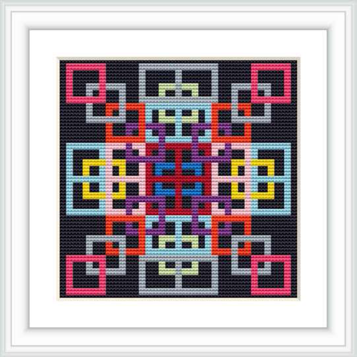 The image displays a framed cross stitch pattern featuring a complex geometric design with multiple colors on a black background.