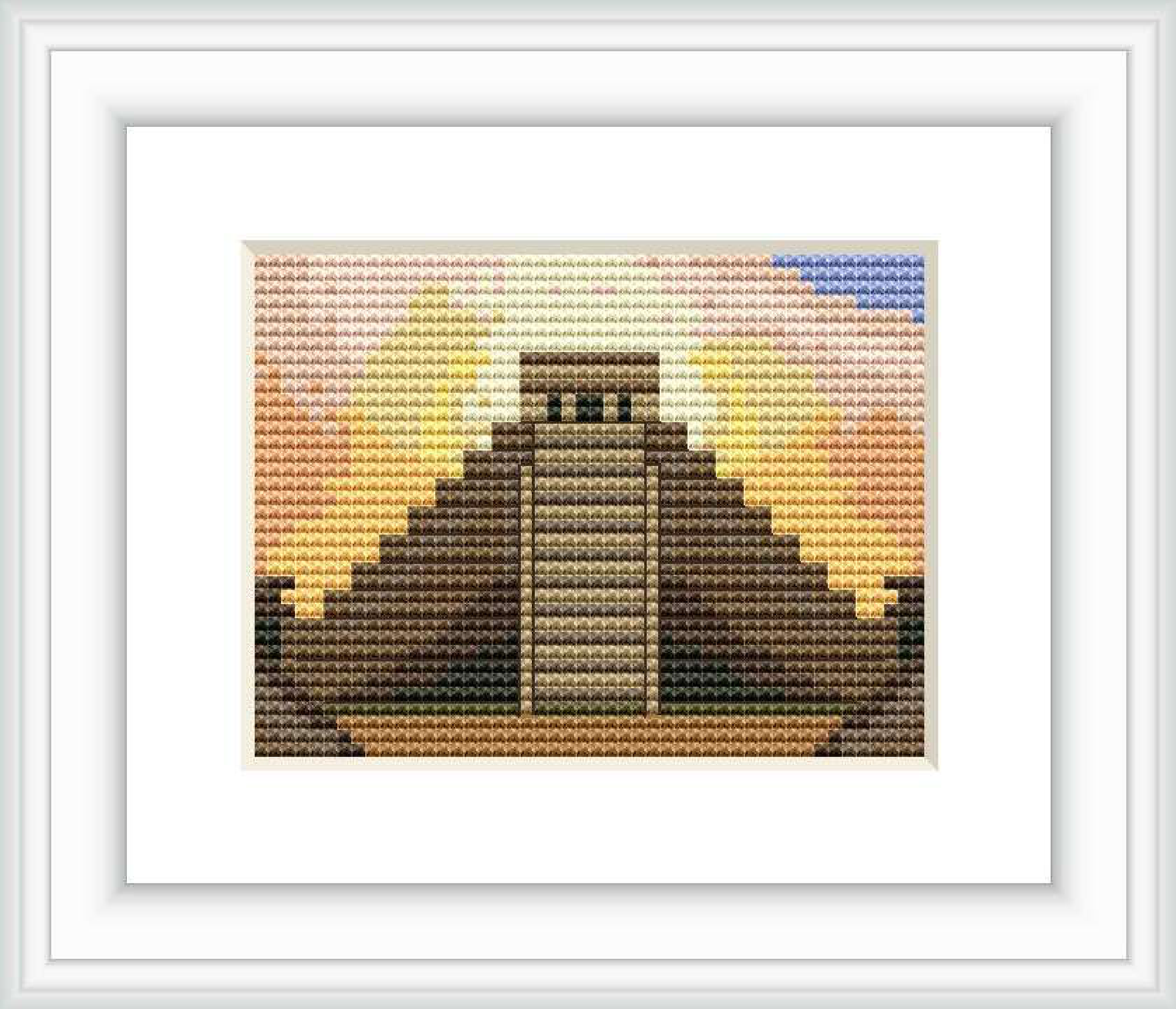 The cross stitch pattern depicts a stylized version of an ancient step pyramid structure found in Mexico, set against a horizontally-gradient background suggestive of a sunset sky. The top section of the sky transitions from blue to yellow, then to orange and brown towards the bottom, representing the ground or lower landscape.