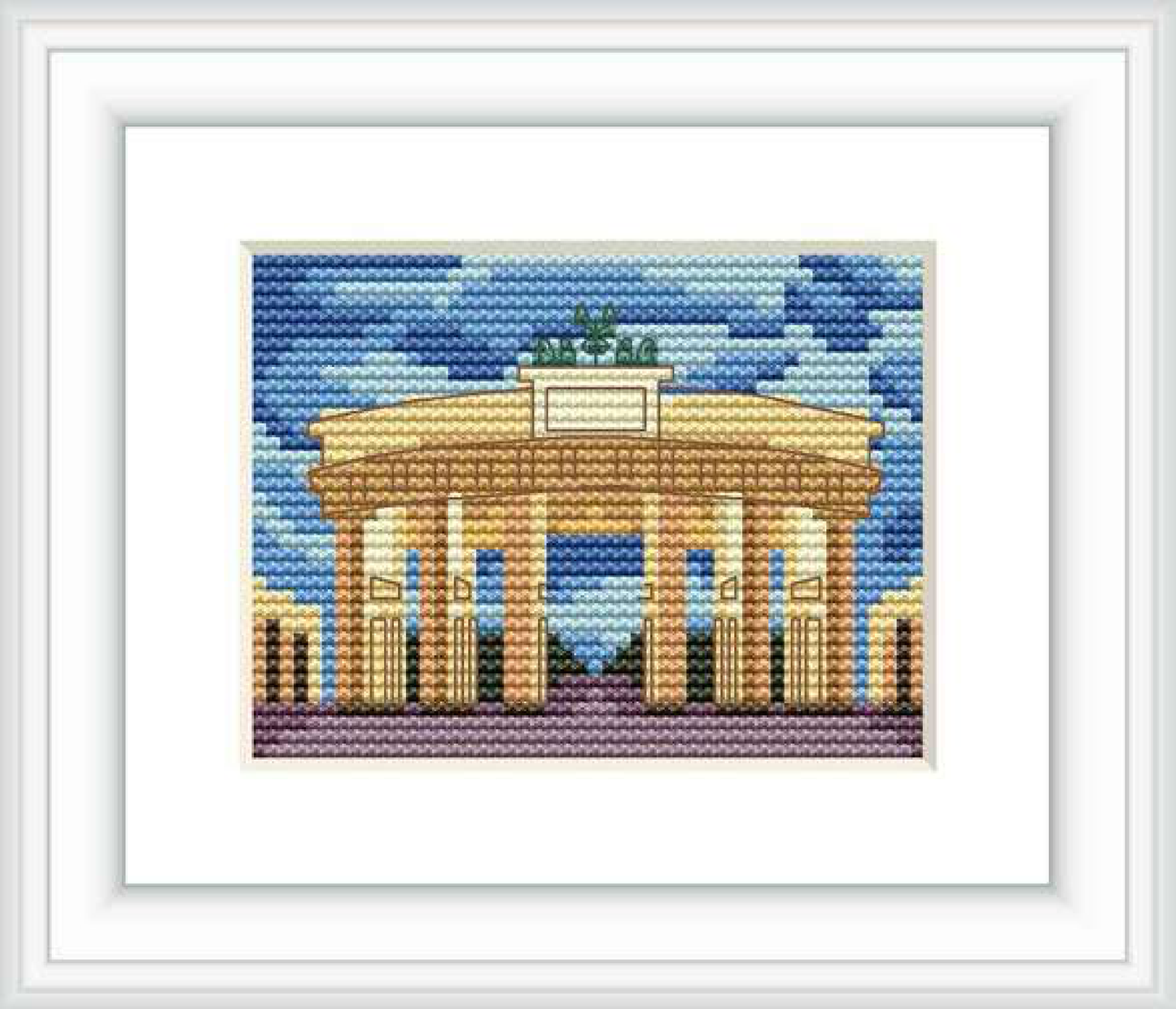 The image showcases the Brandenburg Gate, a neoclassical monument with multiple columns and an upper sculpture, set against a sky with varying shades of blue, designed as a cross stitch pattern within a frame.