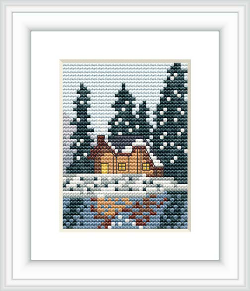 This cross stitch pattern features a tranquil winter scene with a small, warmly lit cabin surrounded by tall pine trees amid gently falling snow. The foreground includes snowy terrain with subtle hints of vegetation peeping through.