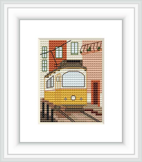 The image depicts a framed cross stitch pattern of a yellow tram with surrounding architectural details against a cream background. The tram is centered, with tracks below and the suggestion of a European street scene.