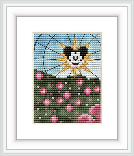 The image shows a framed cross stitch pattern. The design features a central, anthropomorphic sun with a smiling face set against a blue sky. Below it is a green field with a scattering of pink blossoms.