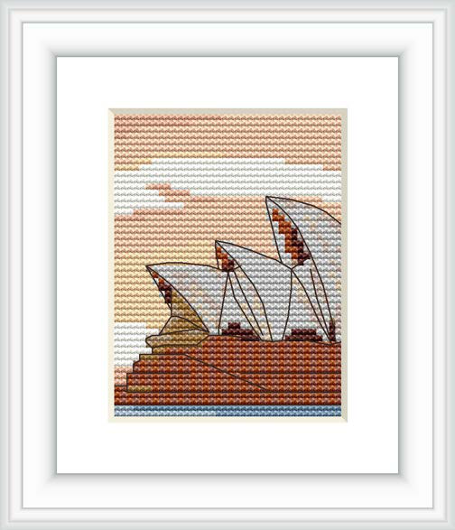 The image shows a cross stitch pattern featuring three sailboats on the water at sunset with a warm sky and the coast visible in the background.