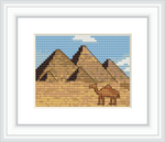 The image depicts a cross stitch pattern with the three Great Pyramids of Giza in the background. In the foreground, there is a camel. The setting appears to be a desert, with a clear sky.