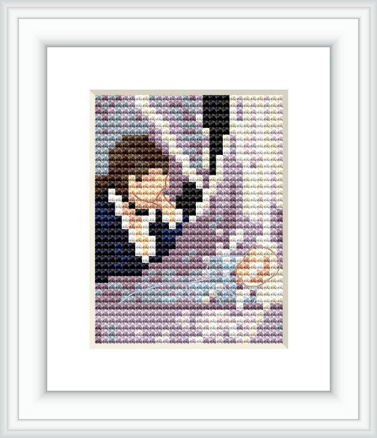 The cross stitch pattern depicts a mother leaning over a cradle where a baby rests. The mother is in profile, her face expressing care and affection. The cradle is placed toward the viewer’s lower right side, signifying the nurturing theme of the design.