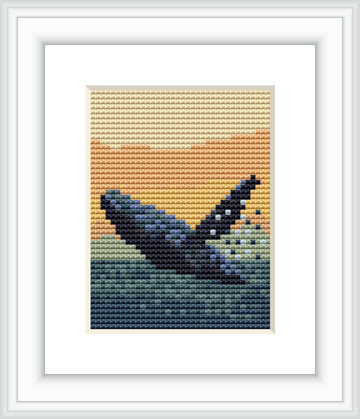 This image displays a framed cross stitch pattern resembling a silhouette of a whale with a sunset background, likely representing the Alaskan scenery.