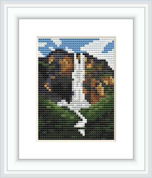 The image depicts a miniature cross stitch pattern of Angel Falls, with the waterfall cascading amongst green scenery and a mountainous backdrop under a blue sky with white clouds.