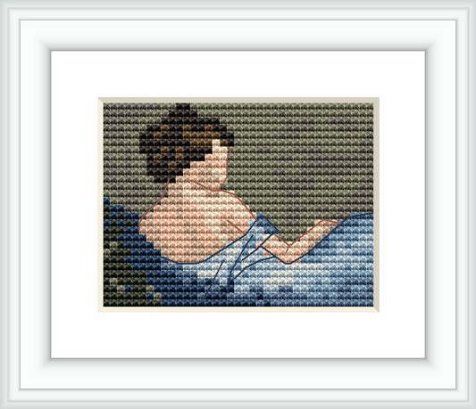 The image depicts a cross stitch pattern of a woman's upper back and head as she appears to be reading. She has dark hair styled up and is wearing a light-colored top against a dark background with a hint of blue, resembling water or night sky.