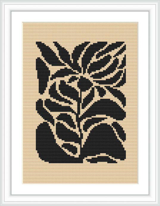The image displays a framed cross stitch pattern featuring a design of stylized black flowers on a beige fabric background, framed by a white border and contained within a decor frame.