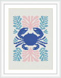 The image features a framed cross stitch pattern of a stylized crab centered on a white fabric. Surrounding the crab are coral-like embellishments in various shades of blue, pink, and coral. The pattern is rendered with a variety of stitches to depict the distinct form of the crab and the decorative elements.
